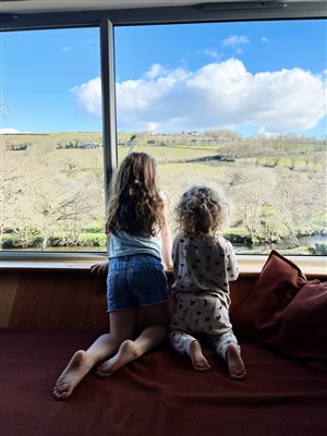 girls looking out a bay window